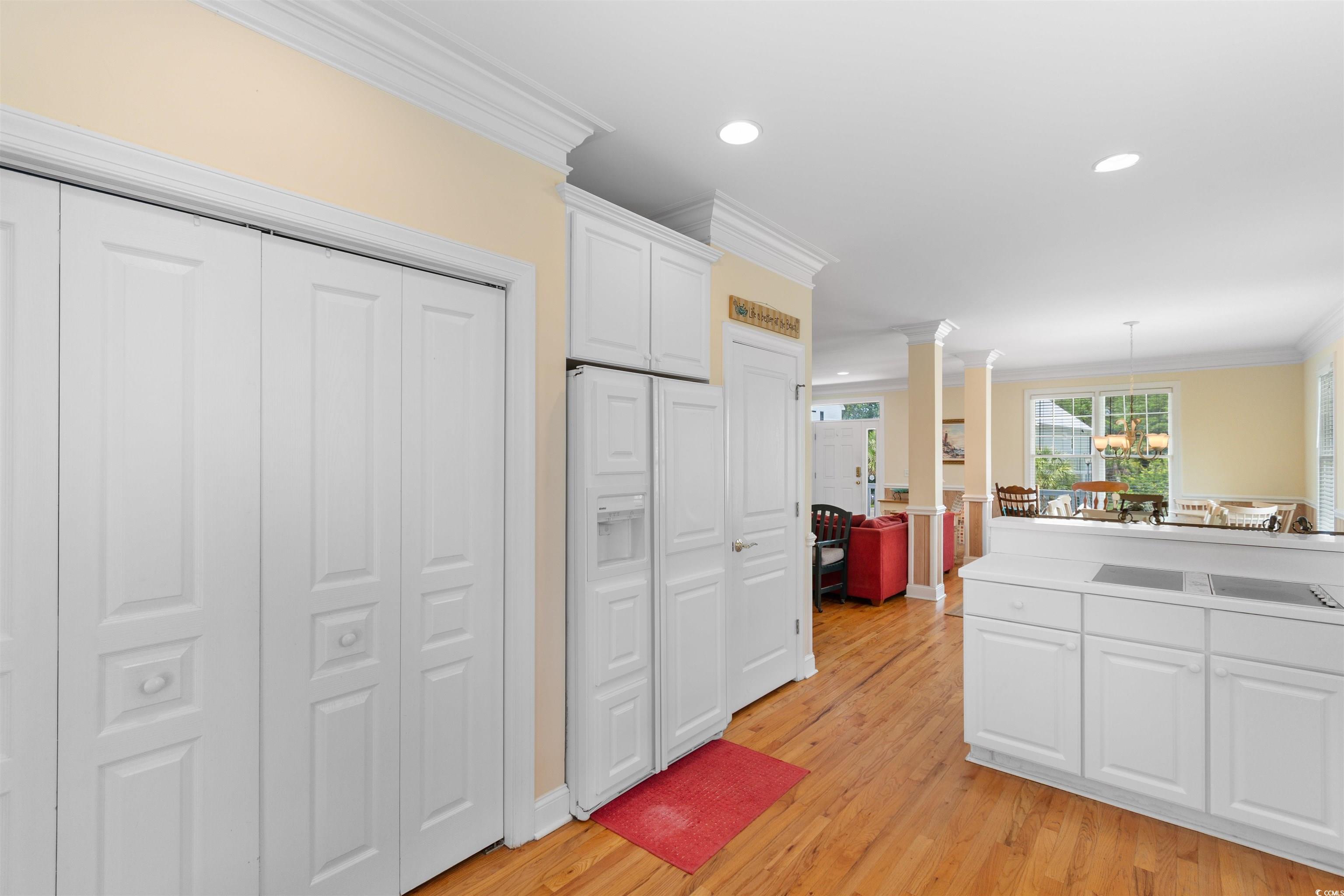 141 Cayman Loop Pawleys Island, SC 29585 - Photo 8 of 40 Kitchen featuring ornamental molding, decorative columns, white cabinets, light wood-style flooring, and recessed lighting