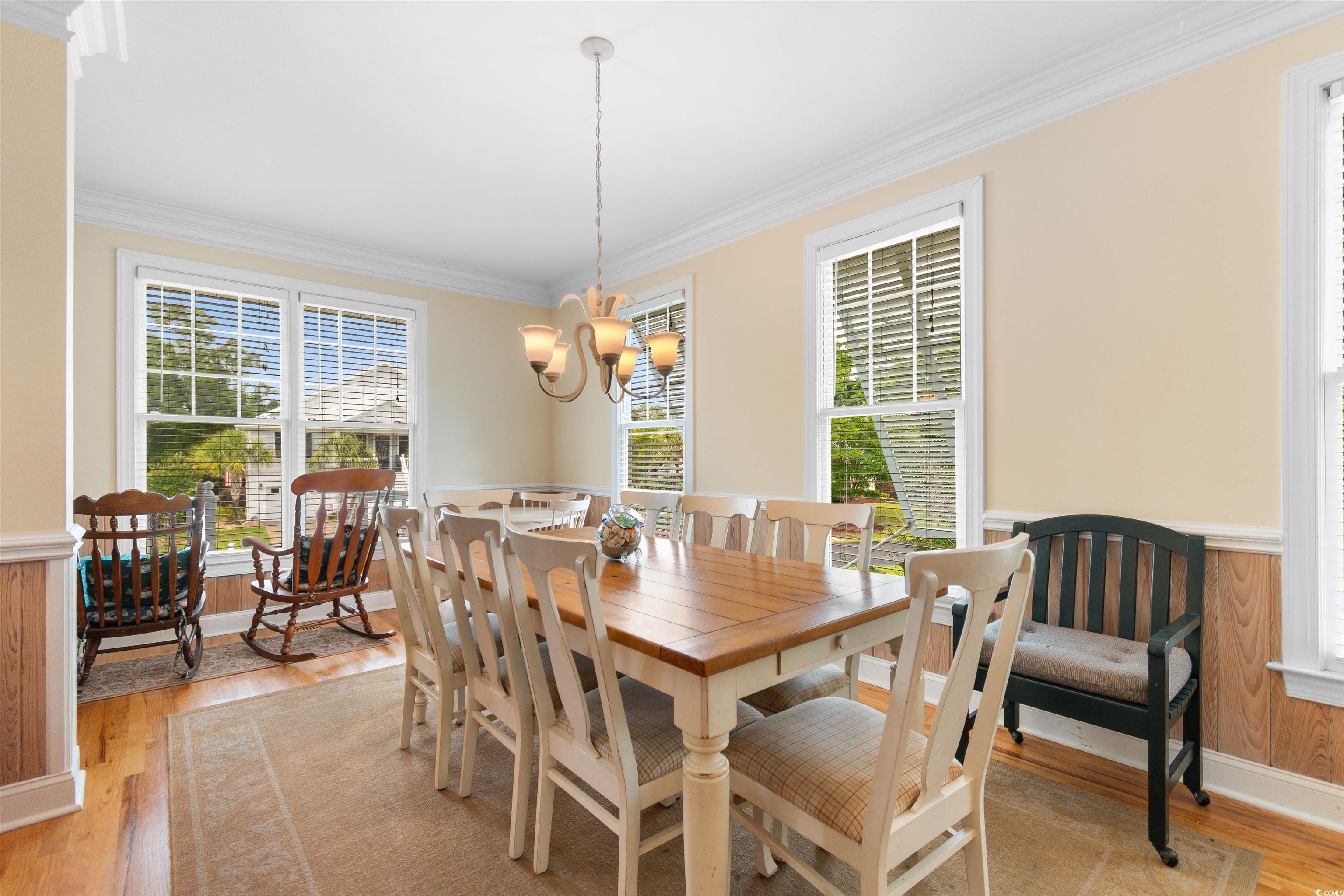 141 Cayman Loop Pawleys Island, SC 29585 - Photo 9 of 40 Dining room with ornamental molding, light wood-type flooring, a chandelier, and wainscoting