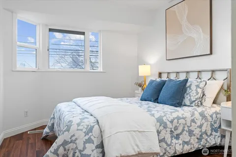 a bedroom with a bed and painting on the wall