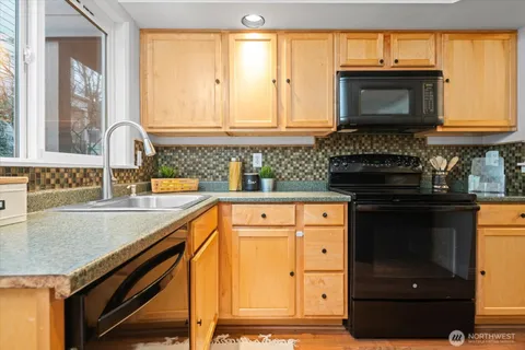 a kitchen with stainless steel appliances granite countertop a stove and a microwave