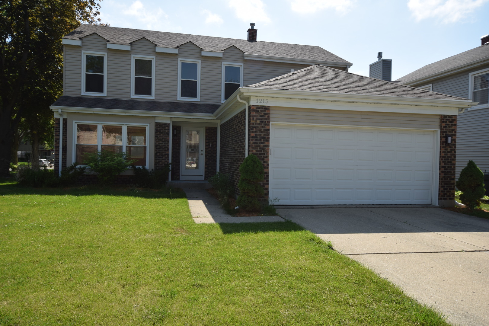 1215 Devonshire Road Buffalo Grove, IL 60089 - Photo 1 of 1 a view of a brick house with a yard