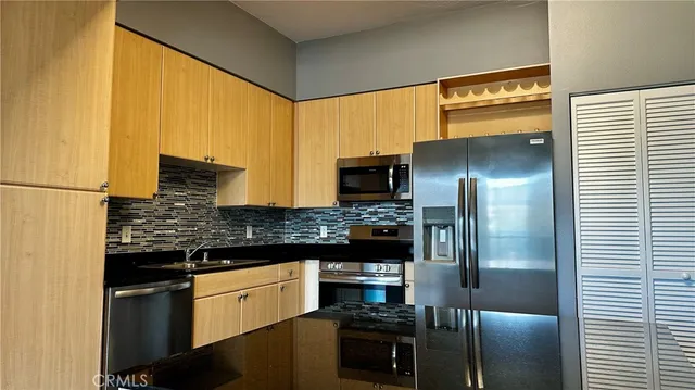 a kitchen with stainless steel appliances granite countertop a refrigerator and a stove