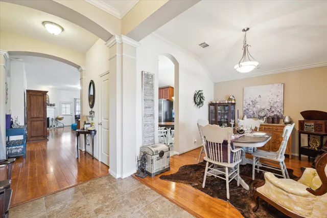 a dining room with wooden floor and a chandelier