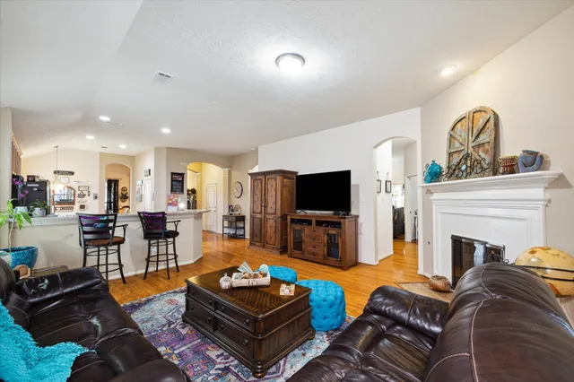 a living room with furniture a flat screen tv and kitchen view