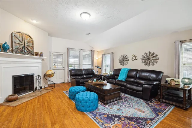 a living room with furniture and a wooden floor