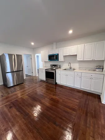 a view of kitchen with wooden floor and electronic appliances