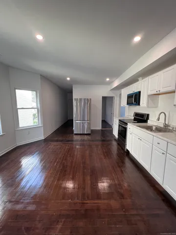 a kitchen with granite countertop a stove and a wooden floors