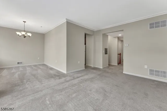 a view of a chandelier in big room and a bathroom