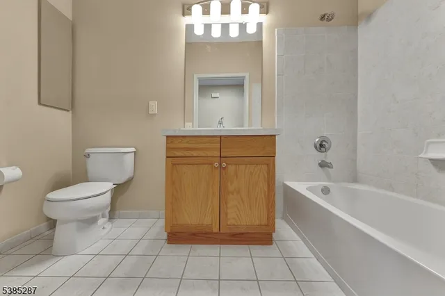a bathroom with a toilet a sink a mirror and bathtub