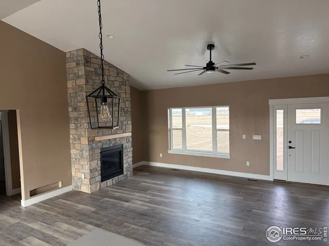 a view of an empty room with a fireplace and a window