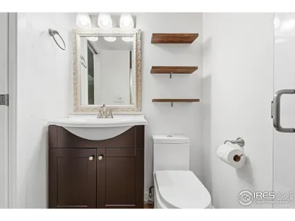 a bathroom with a sink vanity mirror and toilet