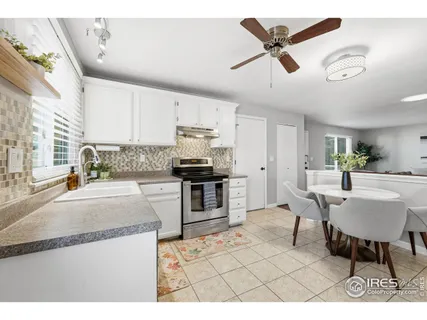 a kitchen with granite countertop a sink cabinets stainless steel appliances and a window