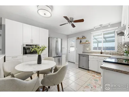 a kitchen with a dining table chairs and white cabinets