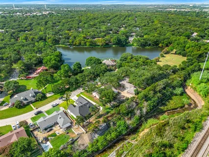 an aerial view of residential houses with outdoor space and trees