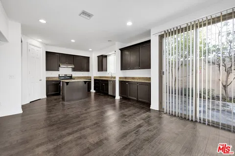 a view of kitchen with microwave stove refrigerator and cabinets