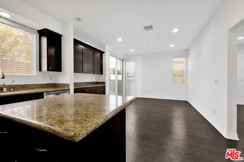 a kitchen with kitchen island a sink appliances and a counter top space