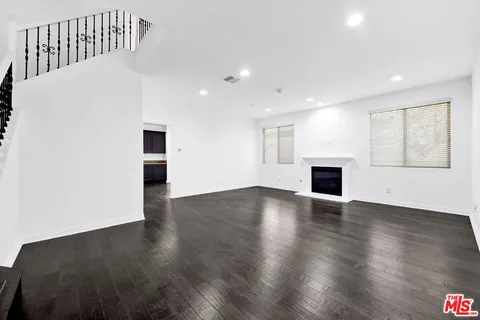a view of empty room with wooden floor and fireplace