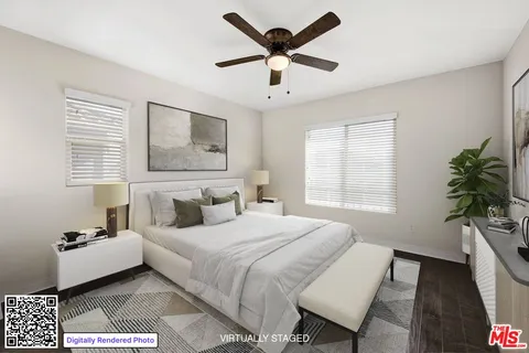 a view of an empty room with wooden floor and a ceiling fan