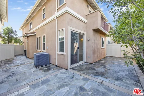 a view of a white house with a yard and plants
