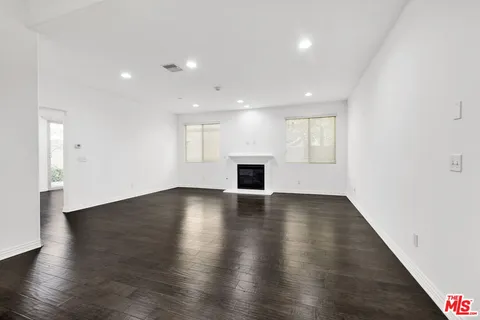 an empty room with wooden floor and fireplace