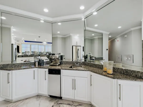 a kitchen with white cabinets sink and stove