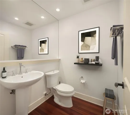 a bathroom with a toilet a sink and mirror
