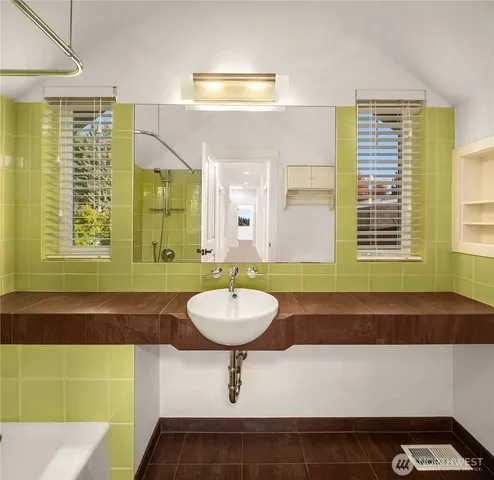 a bathroom with a sink a bathtub and a mirror