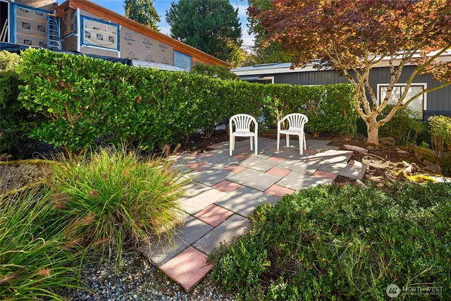 a view of a patio with table and chairs potted plants and large tree