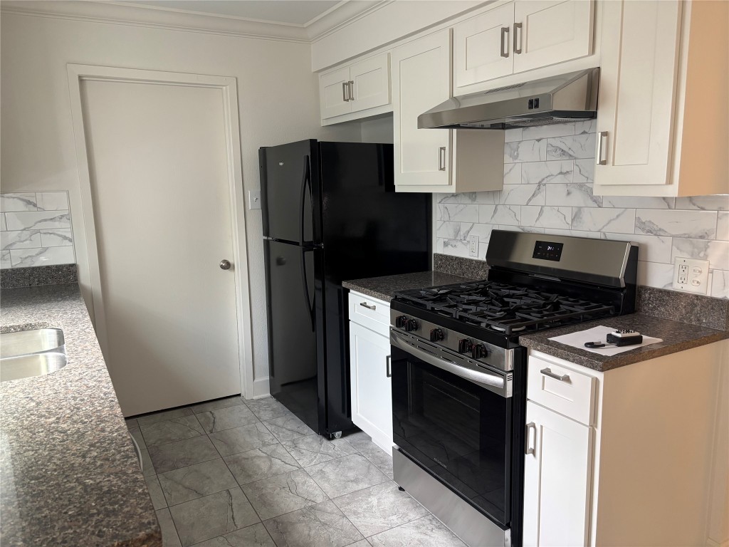 a kitchen with stainless steel appliances granite countertop a stove and a refrigerator
