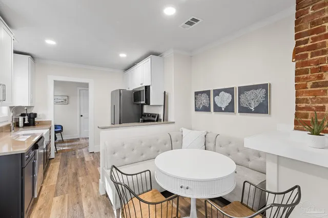 a living room with furniture a flat screen tv and kitchen view