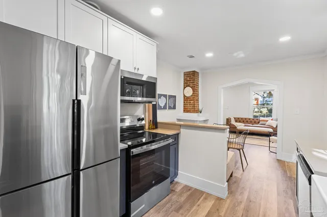 a kitchen with stainless steel appliances a refrigerator and a stove top oven