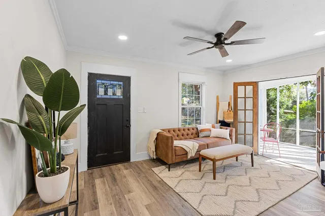 a living room with furniture a window and a potted plant
