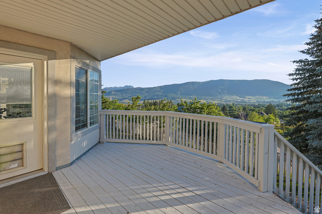 4117 North Wolf Ridge Circle Eden, UT 84310 - Photo 52 of 63 Expansive outdoor deck with white wood railings and a sweeping mountain backdrop