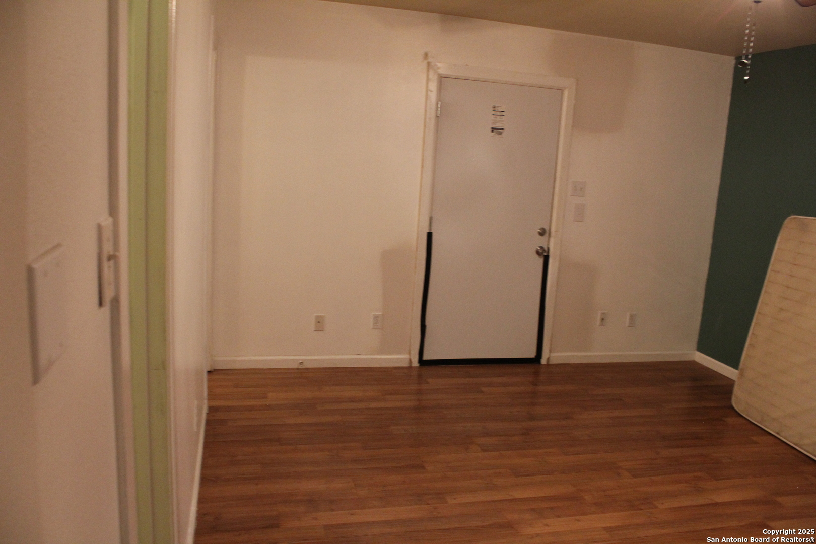 406 County Road 6850, Unit 1 Lytle, TX 78052 - Photo 11 of 24 a view of an empty room with wooden floor and a chair