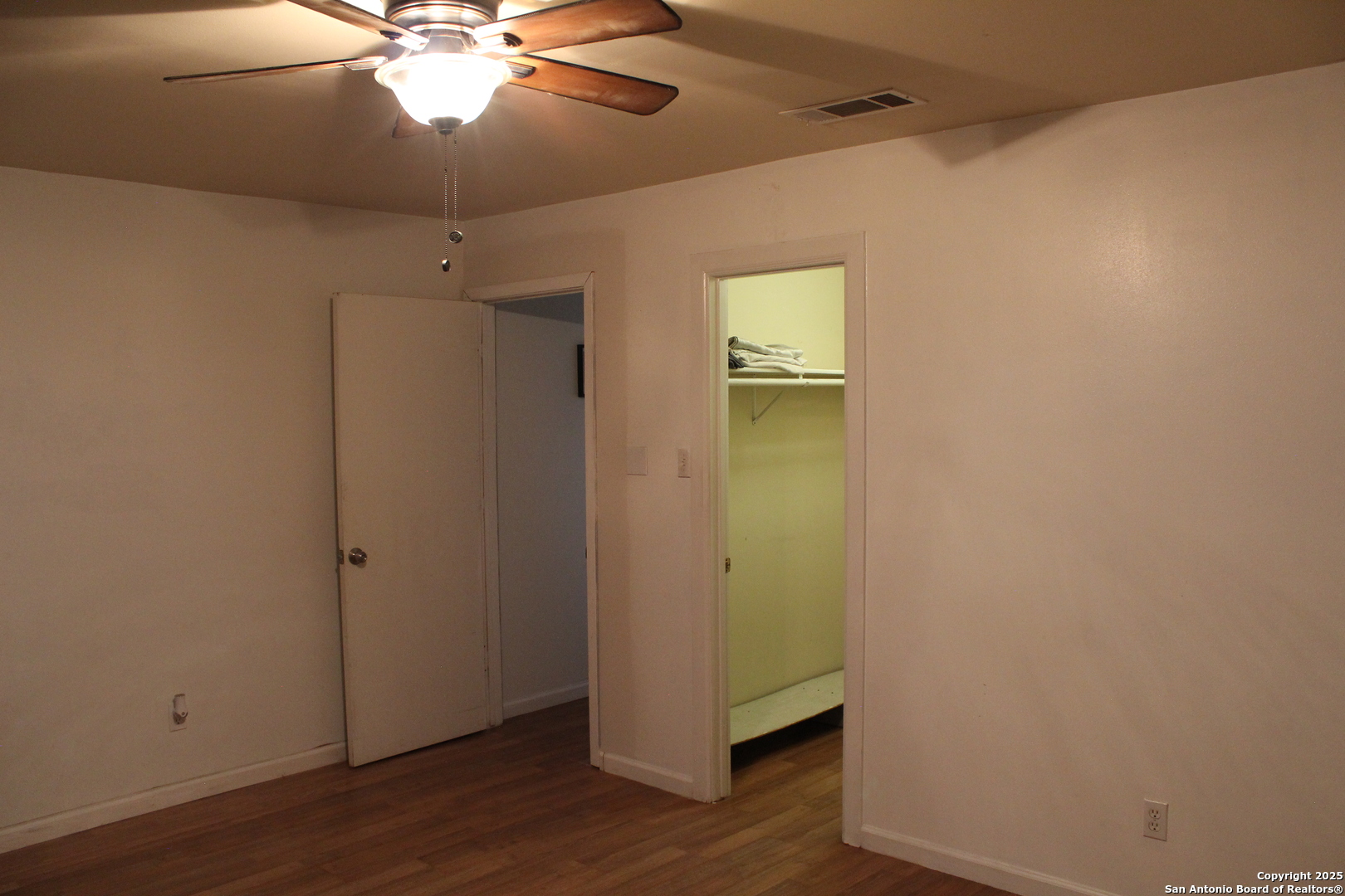 406 County Road 6850, Unit 1 Lytle, TX 78052 - Photo 13 of 24 an empty room with wooden floor and fan