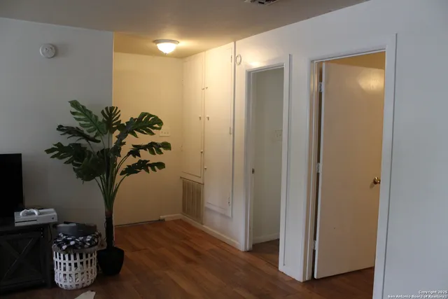 a view of entryway with livingroom a potted plant and wooden floor