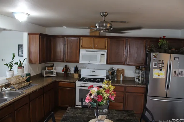 a kitchen with stainless steel appliances granite countertop a refrigerator sink and cabinets