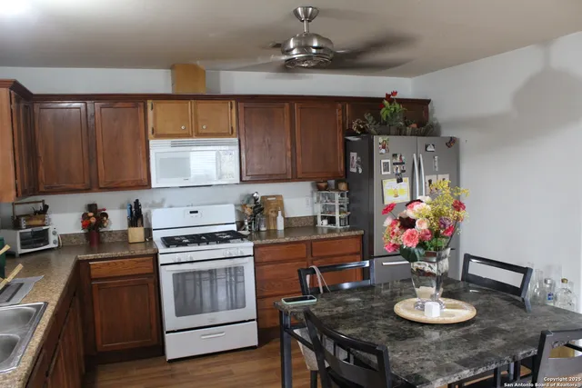 a kitchen with stainless steel appliances a stove a sink cabinets and a dining table