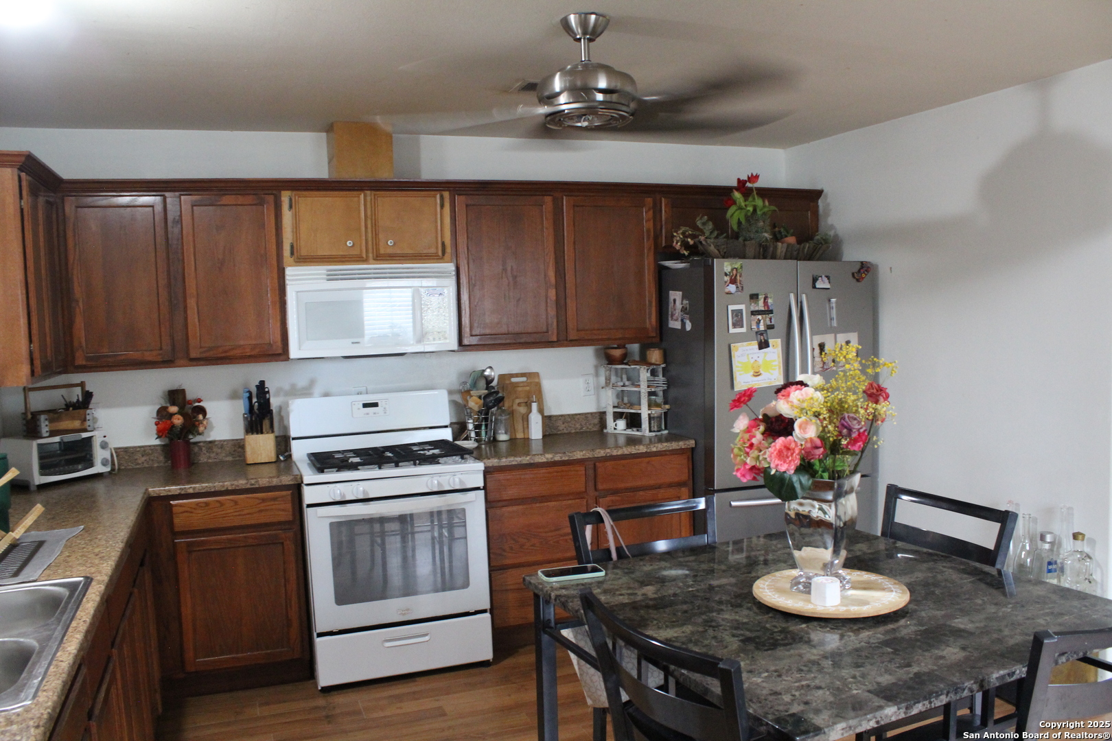 406 County Road 6850, Unit 1 Lytle, TX 78052 - Photo 5 of 24 a kitchen with stainless steel appliances a stove a sink cabinets and a dining table