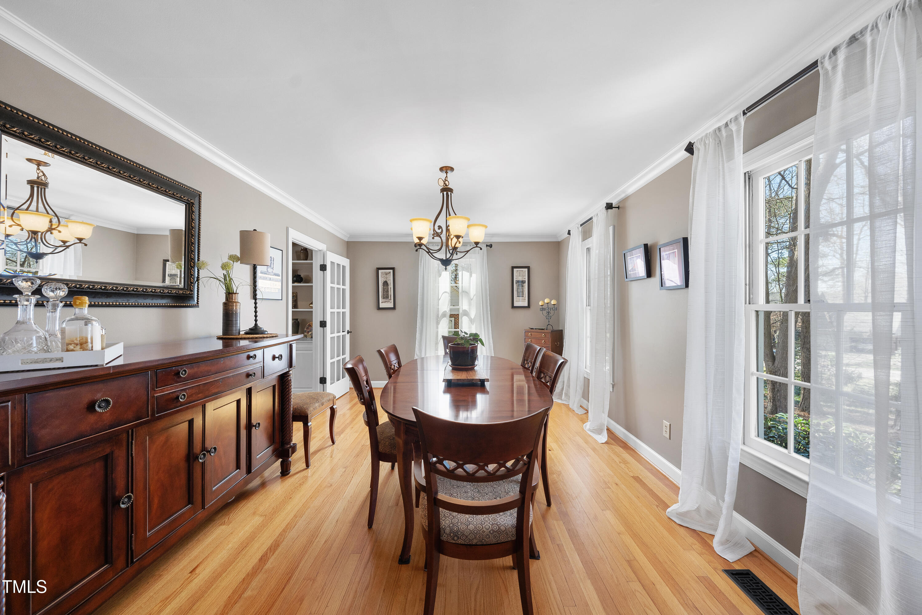 8616 Seagate Drive Raleigh, NC 27615 - Photo 23 of 56 a view of a dining room with furniture a chandelier and wooden floor