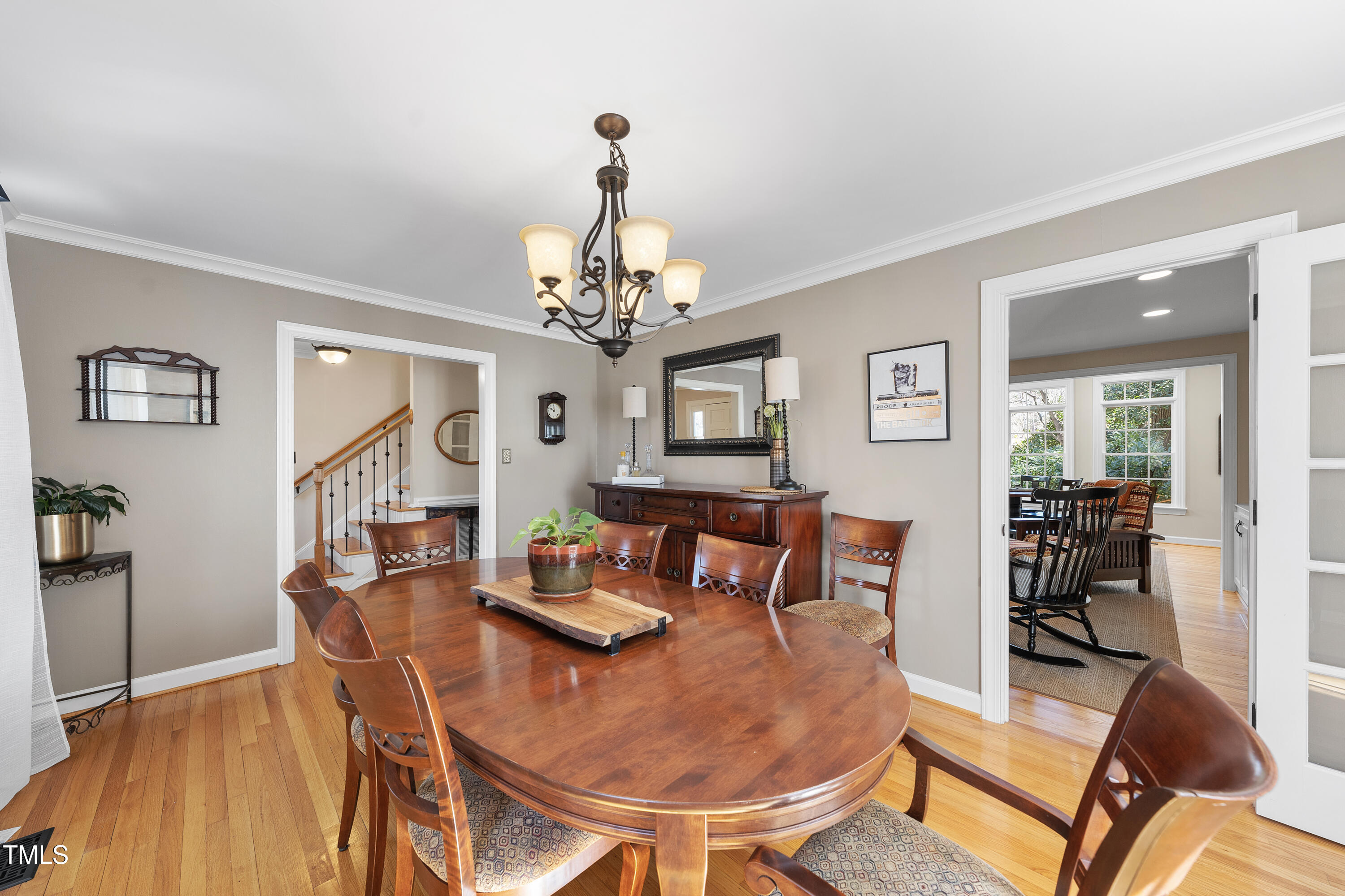 8616 Seagate Drive Raleigh, NC 27615 - Photo 24 of 56 a view of a dining room with furniture a chandelier and wooden floor