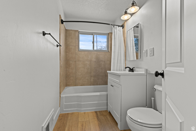 2101 West 3900th Street South Roy, UT 84067 - Photo 15 of 36 Bathroom featuring a white vanity with a dark faucet, a toilet, and a bathtub with tile surround