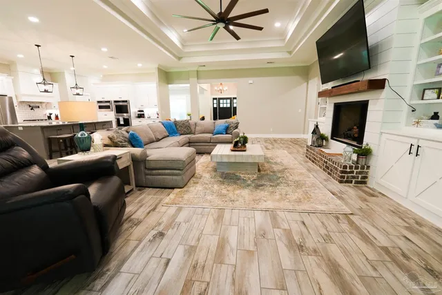 a living room with furniture a flat screen tv and kitchen view