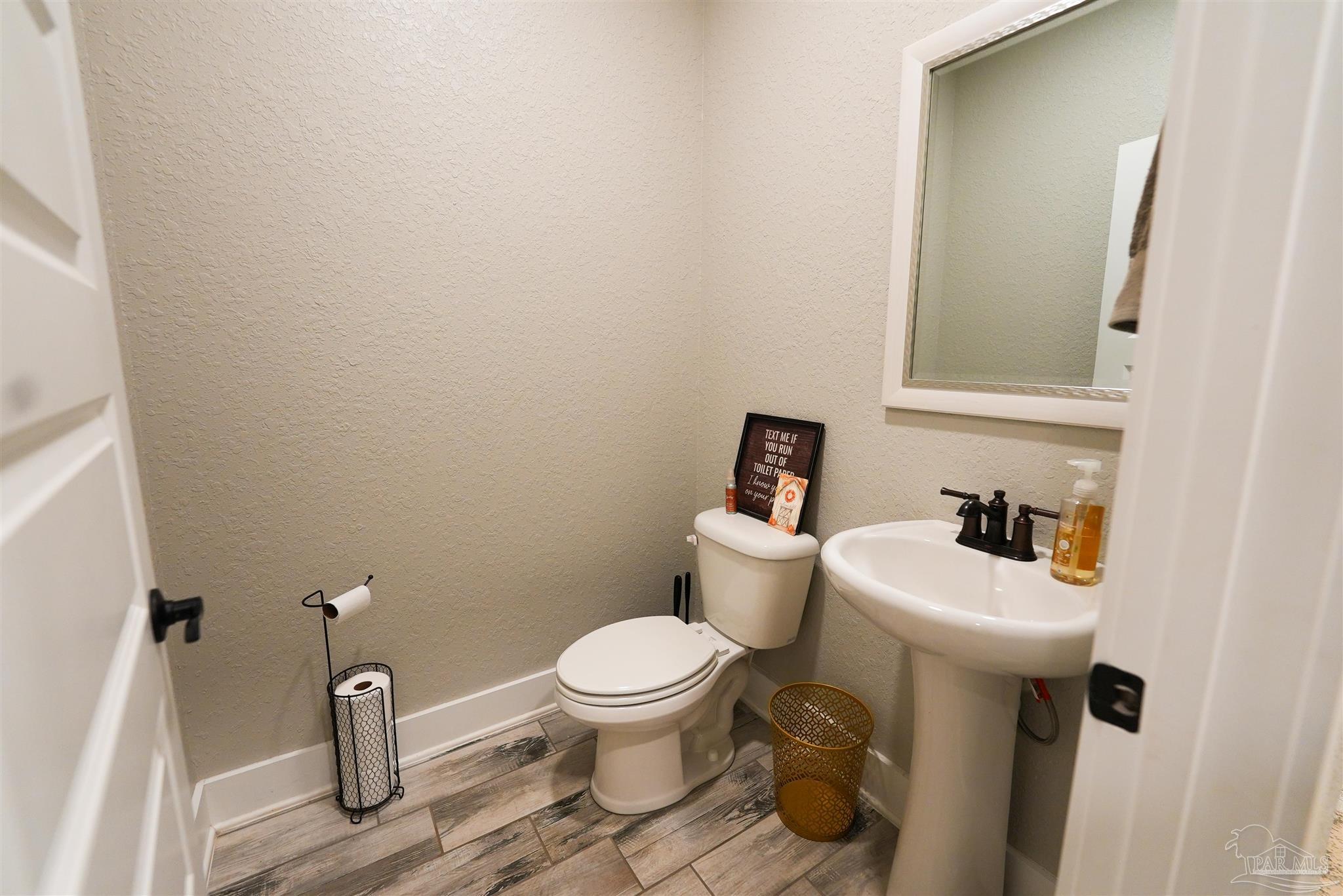 8410 Highway 97 Walnut Hill, FL 32568 - Photo 38 of 66 a bathroom with a toilet sink and mirror