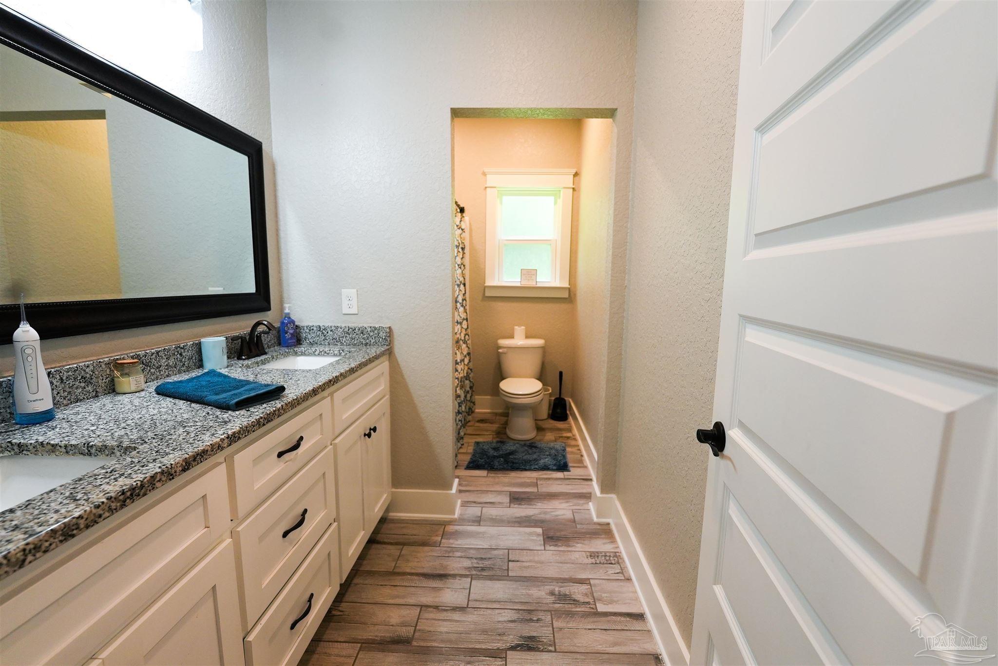 8410 Highway 97 Walnut Hill, FL 32568 - Photo 46 of 66 a bathroom with a granite countertop sink and a mirror
