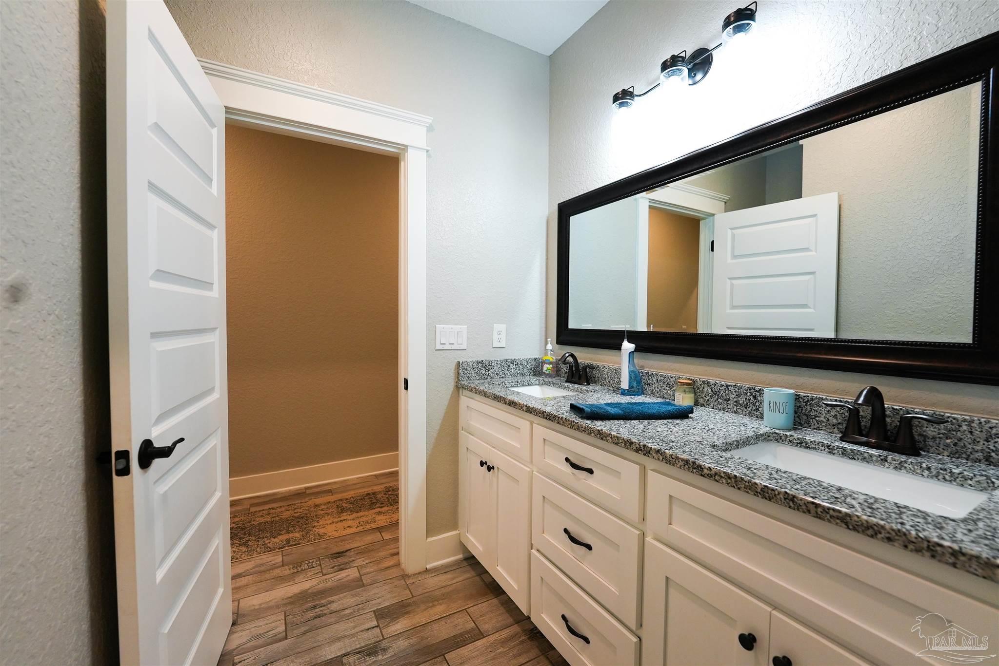 8410 Highway 97 Walnut Hill, FL 32568 - Photo 49 of 66 a bathroom with a granite countertop sink and a mirror