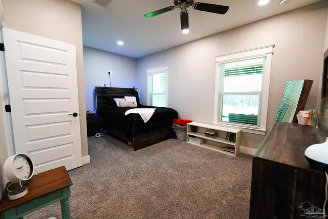 an aerial view of a house with yard and trees all around