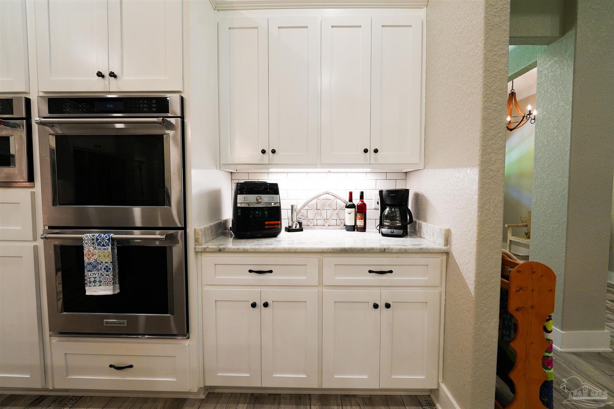 8410 Highway 97 Walnut Hill, FL 32568 - Photo 8 of 66 a kitchen with white cabinets and black appliances