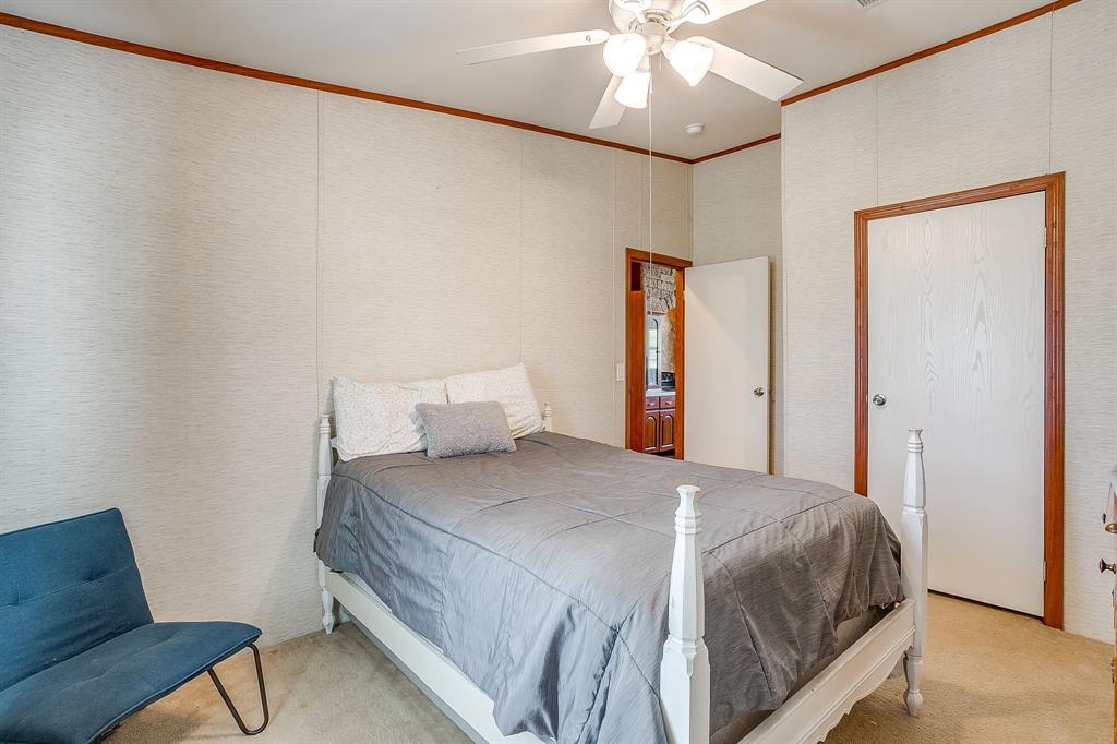 321 Young Road Millsap, TX 76066 - Photo 21 of 28 a bedroom with a bed and a chandelier