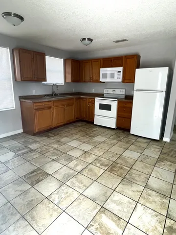 a kitchen with stainless steel appliances granite countertop a stove a sink and a granite counter top